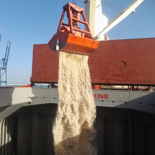 Salt pouring from a grab into a bulk carrier’s hold